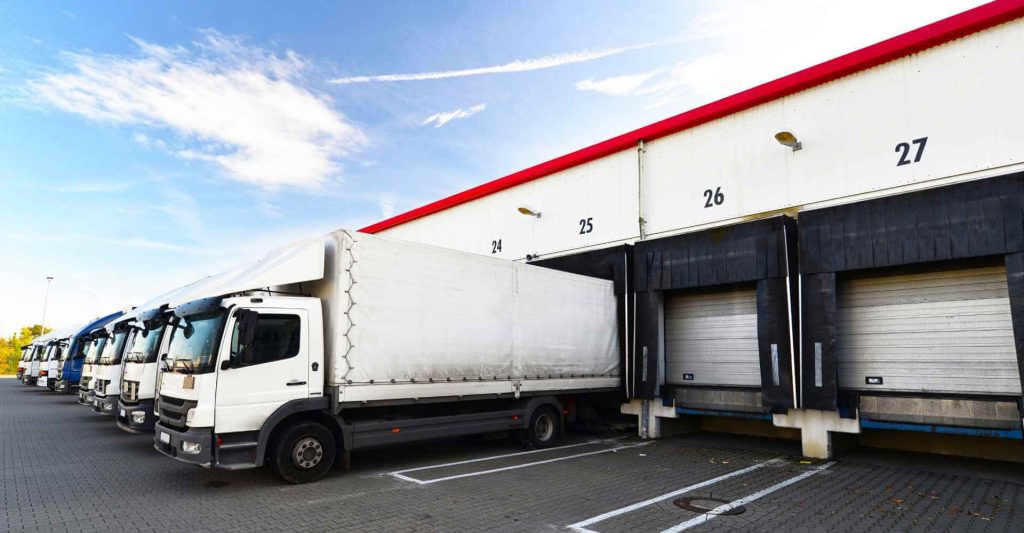 Trucks queued at a warehouse loading dock for consolidated cargo